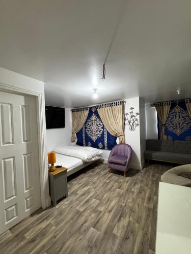 a bedroom with a bed and a purple chair at OYO Unique Guestroom - Farnworth, Easy Access to Bolton in Farnworth