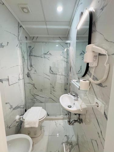 a white bathroom with a sink and a shower at Casa Roma in Rome