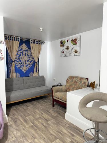 a living room with a couch and a chair at OYO Unique Guestroom - Farnworth, Easy Access to Bolton in Farnworth