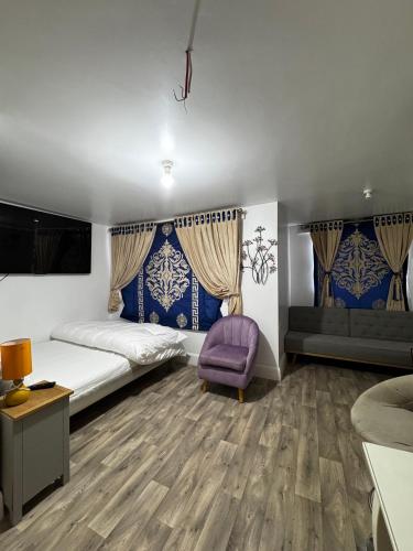 a bedroom with two beds and a purple chair at OYO Unique Guestroom - Farnworth, Easy Access to Bolton in Farnworth
