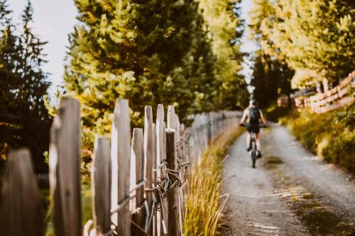 a person riding a bike down a dirt road at Hotel Bergschlössl in Luson