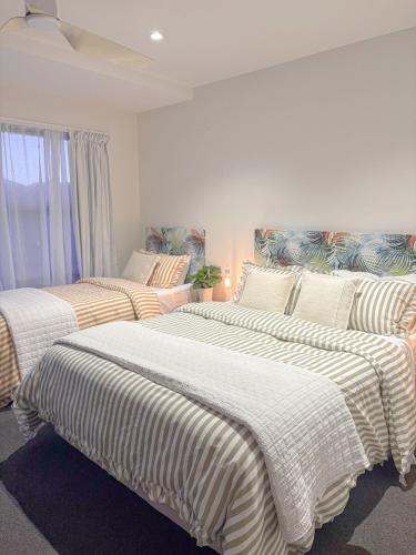 a bedroom with two beds with striped blankets at Tropicana Bijou - Studio & Spa in Carters Beach