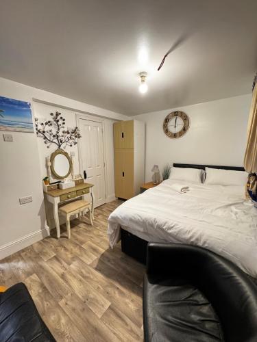 a bedroom with a bed and a clock on the wall at OYO Unique Guestroom - Farnworth, Easy Access to Bolton in Farnworth