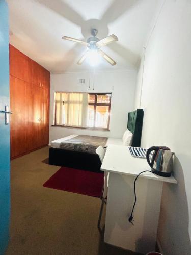 a room with a bed and a ceiling fan at Executive Accommodation Bellville 2 in Cape Town