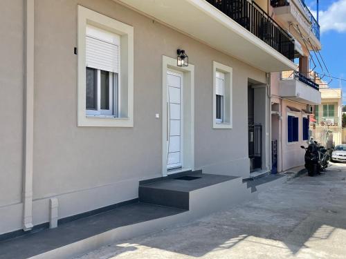 a house with a white door and a motorcycle parked next to it at Suite V in Argostoli