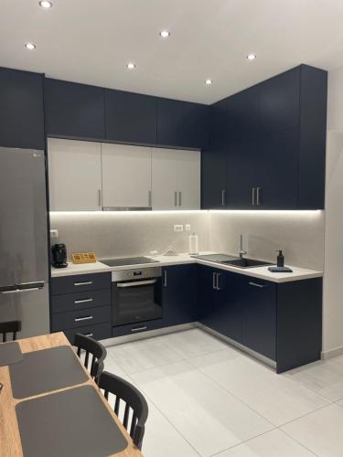 a kitchen with dark blue cabinets and a table and a table and chairs at Suite V in Argostoli