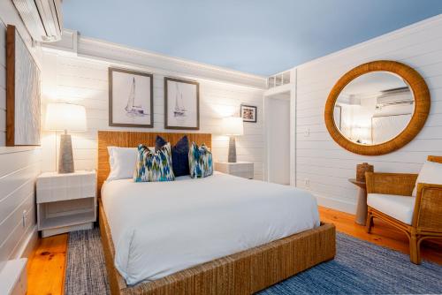 a bedroom with a bed and a mirror and a chair at Anchor Inn in Nantucket
