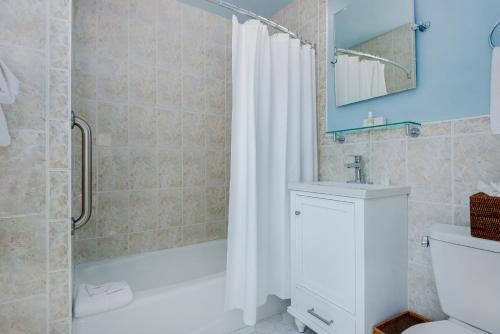 a bathroom with a shower curtain and a toilet and a sink at Anchor Inn in Nantucket