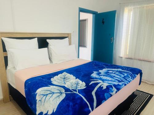 a bed with a blue and white blanket on it at Executive Accommodation Bellville 2 in Cape Town