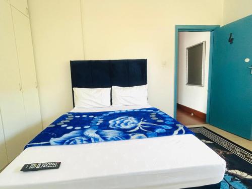 a bed with a blue and white comforter and a remote control at Executive Accommodation Bellville 2 in Cape Town