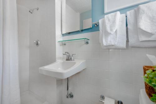 a white bathroom with a sink and towels at Anchor Inn in Nantucket