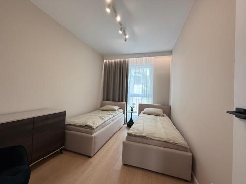 a bedroom with two beds and a window at Apartamenty Klonova Park in Olecko