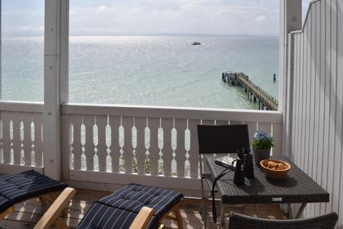 a balcony with a table and chairs and the ocean at Fürstenhof Sassnitz in Sassnitz