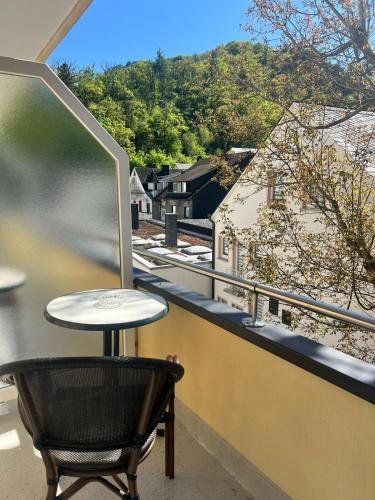 a table and a chair on a balcony with a view at Hotel Haus Christa in Bad Bertrich