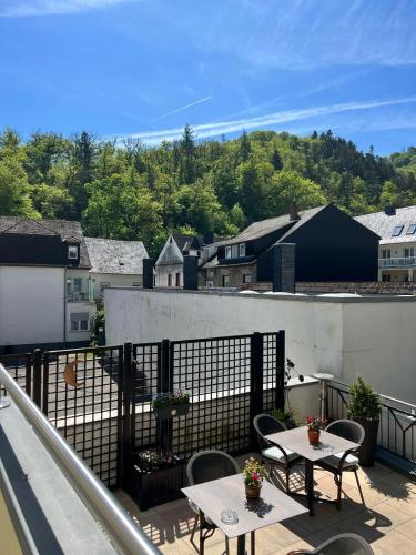 a balcony with tables and chairs and a view of a city at Hotel Haus Christa in Bad Bertrich