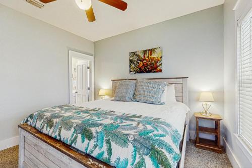 Un dormitorio con una cama y un ventilador de techo. en Barefoot Cottages #B16, en Highland View