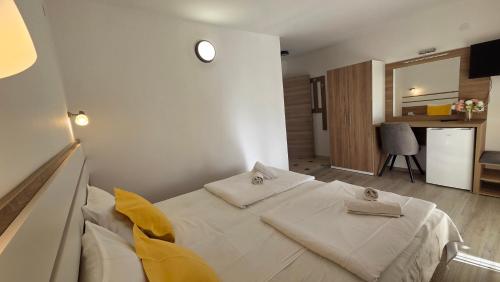 a bedroom with a large white bed with yellow sheets at Apartments Picioski in Peštani