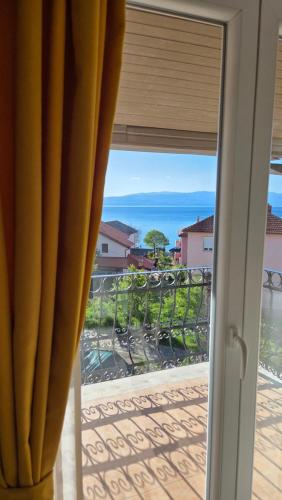 a sliding glass door with a view of the ocean at Apartments Picioski in Peštani