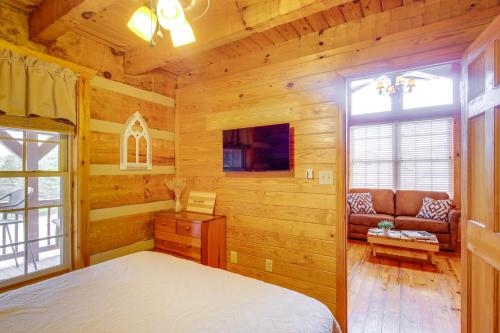 a bedroom in a log cabin with a bed and a couch at Rivers View - Cherokee Lake Cabin with Fire Pit! in Bean Station