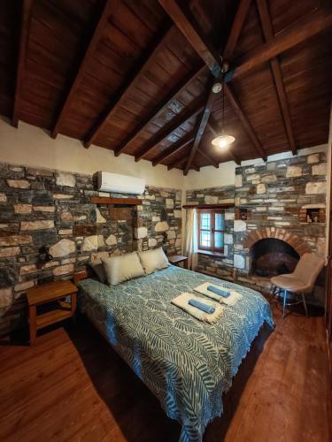 a bedroom with a bed and a stone wall at Villa Hera Doğanbey in Doğanbey