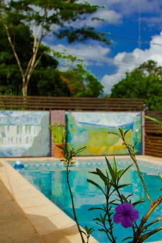a plant with a purple flower in front of a mural at Casitas Nuova Villa in Puerto Iguazú