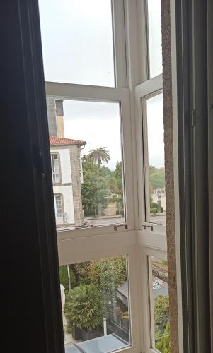 an open window with a view of a house at Restaurante y Hostal San Paio in Santiago de Compostela