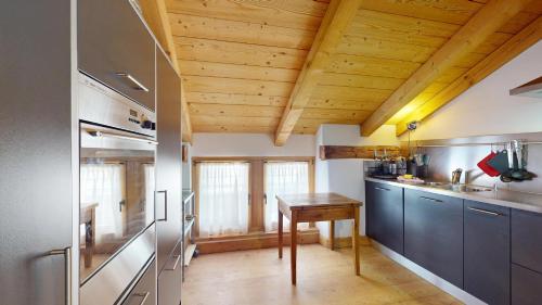 a kitchen with a wooden ceiling and a wooden table at Abitaziun Chascharia 8 - Samedan in Samedan