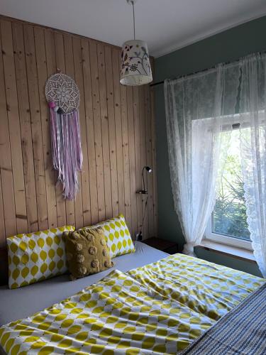 a bedroom with a bed with a yellow and white checkered blanket at Domek letniskowy "Pod dębem" in Urowo
