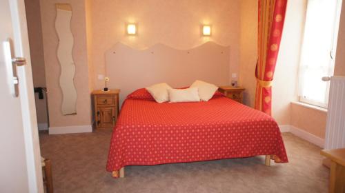 a bedroom with a red bed and two windows at Auberge De Raulhac in Raulhac
