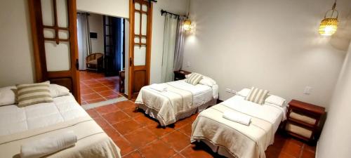 a hotel room with two beds and a hallway at Las Moras Hotel in San Lorenzo