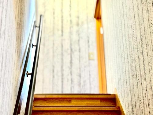 a staircase leading to a door in a building at Hummingbird Kanazawa in Kanazawa
