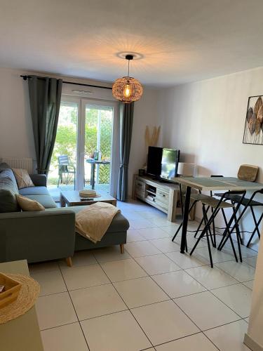 un salon avec un canapé et une table dans l'établissement Joli appartement à Andernos les bains , 2 ou 4 pers , avec terrasse et parking, à Andernos-les-Bains
