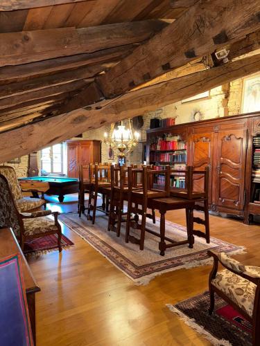 une salle à manger avec une table et une bibliothèque dans l'établissement Art & Relaxation Manor Spa, Billiards & Pinball, à Spincourt