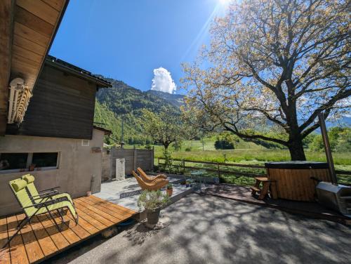a patio with a table and chairs and a tree at Mitten in den Glarner Alpen Hot Tub & Alpenblick in Ennenda