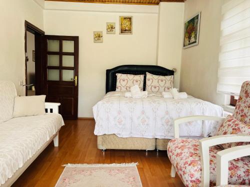 a bedroom with a bed and a couch and a chair at Eren Villa in Sapanca