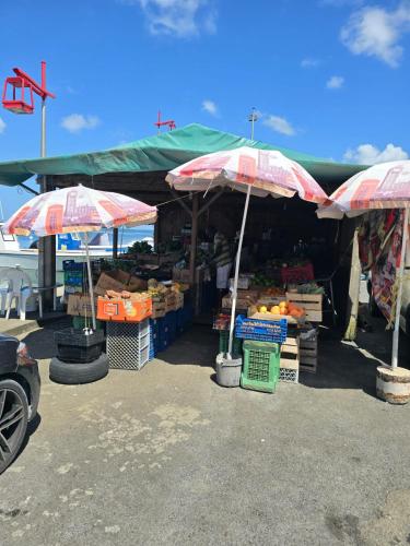 a market with umbrellas and crates of fruits and vegetables at Bungalow le Refuge Vert in Morne-à-lʼEau