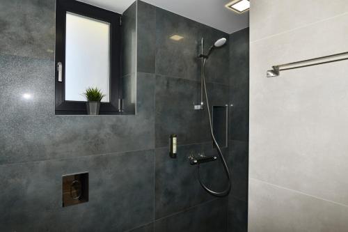 Un baño con ducha con puerta de cristal. en Апартамент Инфинити, en Veliko Tŭrnovo