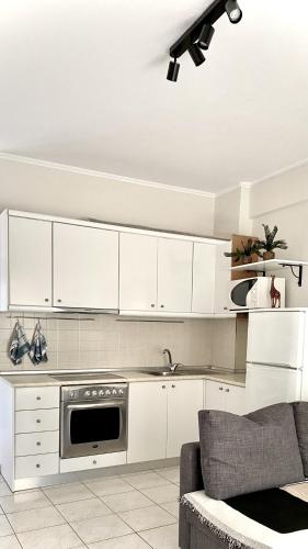 a kitchen with white cabinets and a stove at Agapidis Apartment in Hanioti