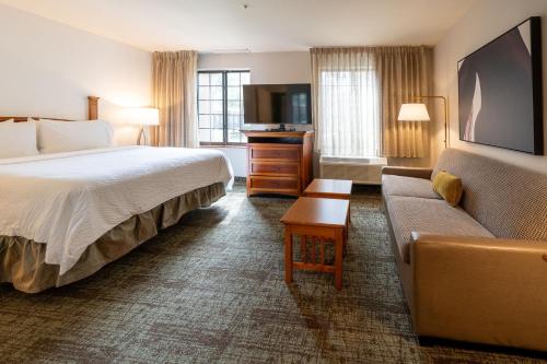 a hotel room with a bed and a couch at Staybridge Suites Houston West - Energy Corridor by IHG in Houston