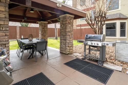 a backyard patio with a grill and a table with chairs at Staybridge Suites Houston West - Energy Corridor by IHG in Houston