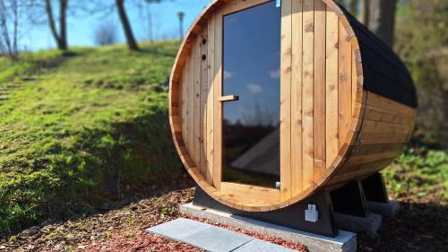 a wooden mirror sitting on a stand in the grass at WesterOurthe 2 personen Sauna in Durbuy