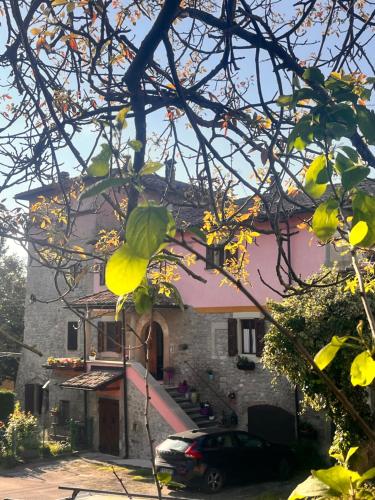 a house with a car parked in front of it at B&B Camelia in Camugnano