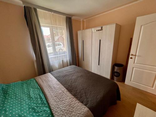 a bedroom with a bed and a large window at Top Apartment in Gheorgheni