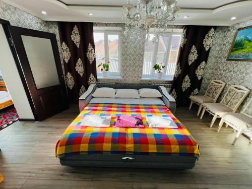 a bedroom with a bed with a colorful blanket at DADOW Guesthouse in Naryn