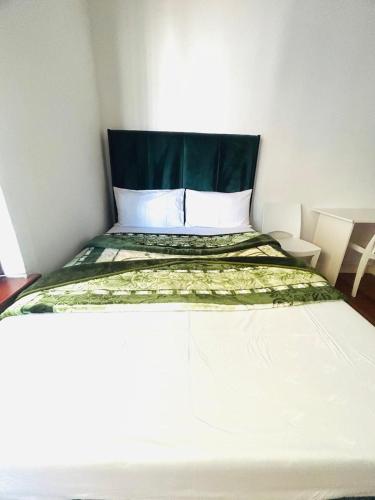 a bedroom with a bed with a green and white comforter at Executive Accommodation Bellville 2 in Cape Town