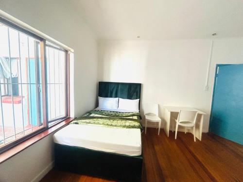 a small bedroom with a bed and a table at Executive Accommodation Bellville 2 in Cape Town