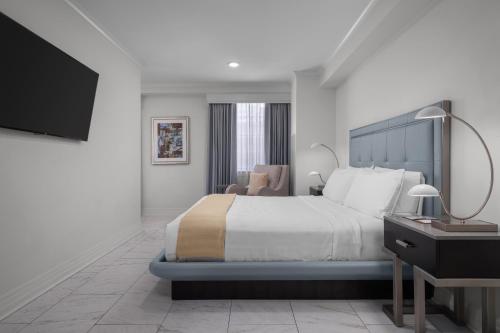 a bedroom with a bed and a desk and a television at The Jung Hotel and Residences in New Orleans