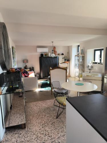 une cuisine et un salon avec une table et des chaises dans l'établissement Charmant lavilledieu, à La Celle-sous-Gouzon