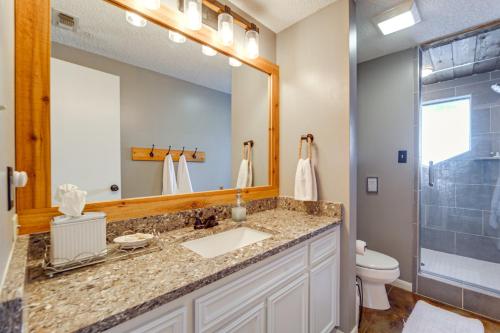 a bathroom with a sink and a toilet and a mirror at The Cove Lakehouse in Spicewood