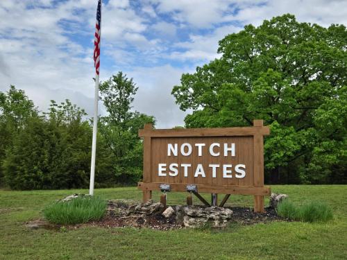 a sign with the words notich easiates in a field at Swan's Woodland Getaway Condo in Reeds Spring